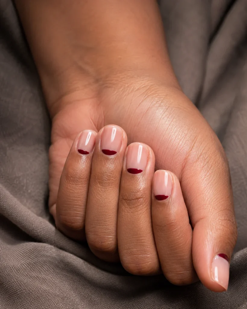19+ Latest Nail Trends for 2026: Colors, Shapes, Designs and Stunning Ideas to Try Sheer nude nails with slim burgundy reverse-French half-moons