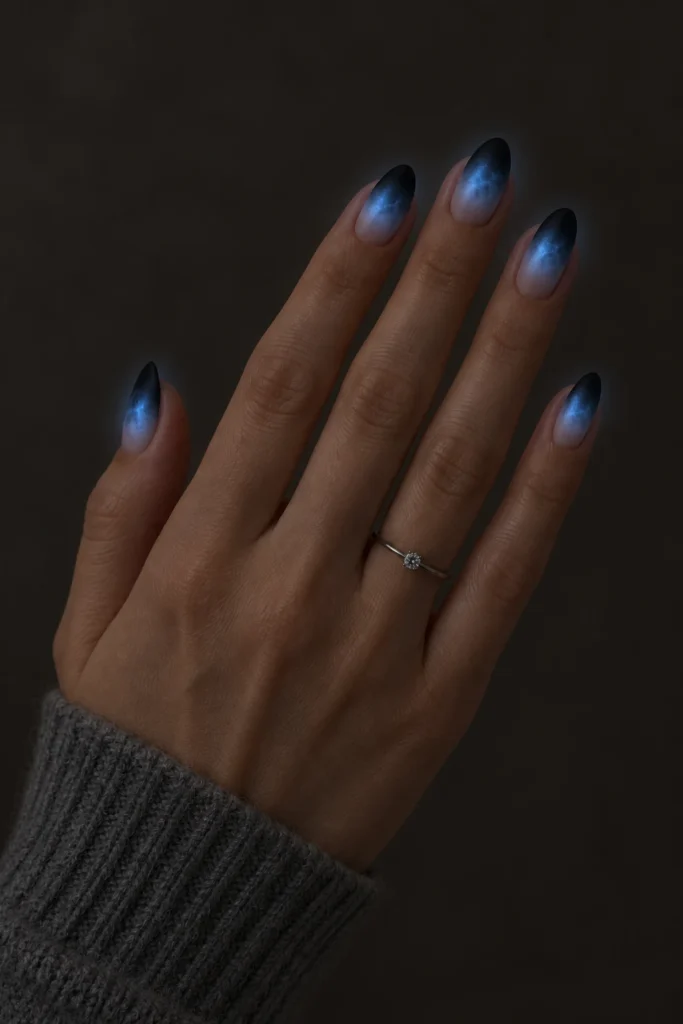 11+ Best Glow-in-the-Dark Short Halloween Nails Smoky gray short Halloween nails glowing ghostly blue in darkness.